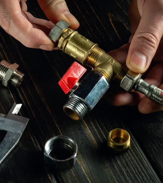 Plumber fitting a brass shutoff valve to a flexible supply line